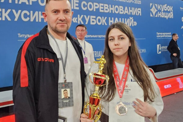 Справа на лево: С кубком и медалью Ангелина Ходарцевич, 1 дан, чёрный пояс. «Кубок Наций», Москва, 3-е место, 2025. Тренер Семашко Андрей Владимирович (клуб “С-4 додзё”, Лида).