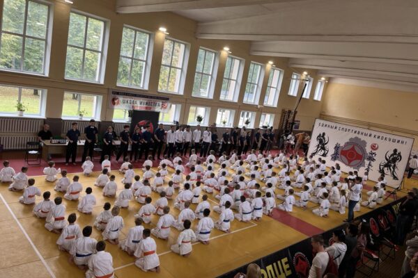 В большом спортивном зале сидят в кимоно ученики клуба "Школа Мужества" из города Минск